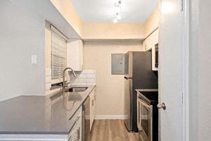 a kitchen with a sink a refrigerator and a stove