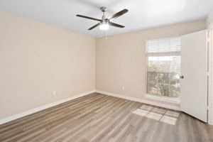an empty room with a ceiling fan and a door