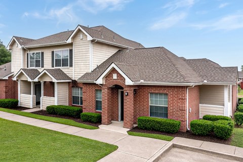 A two-story house with a red brick front and a grey roof.