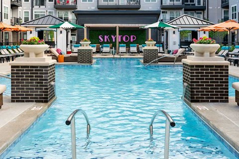 A pool with a sign that says "SKYTOP" behind it.