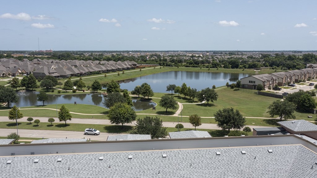 an aerial view of a pond in a neighborhood with houses