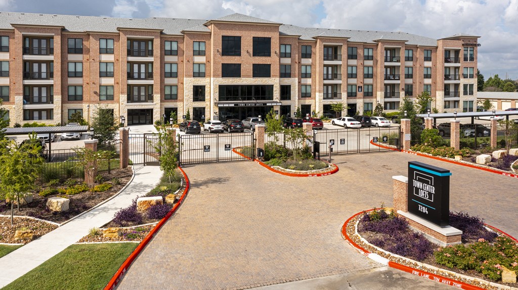 an empty parking lot in front of an apartment building