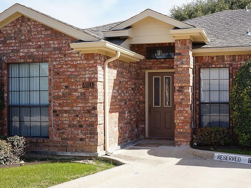 a red brick house with a brown door