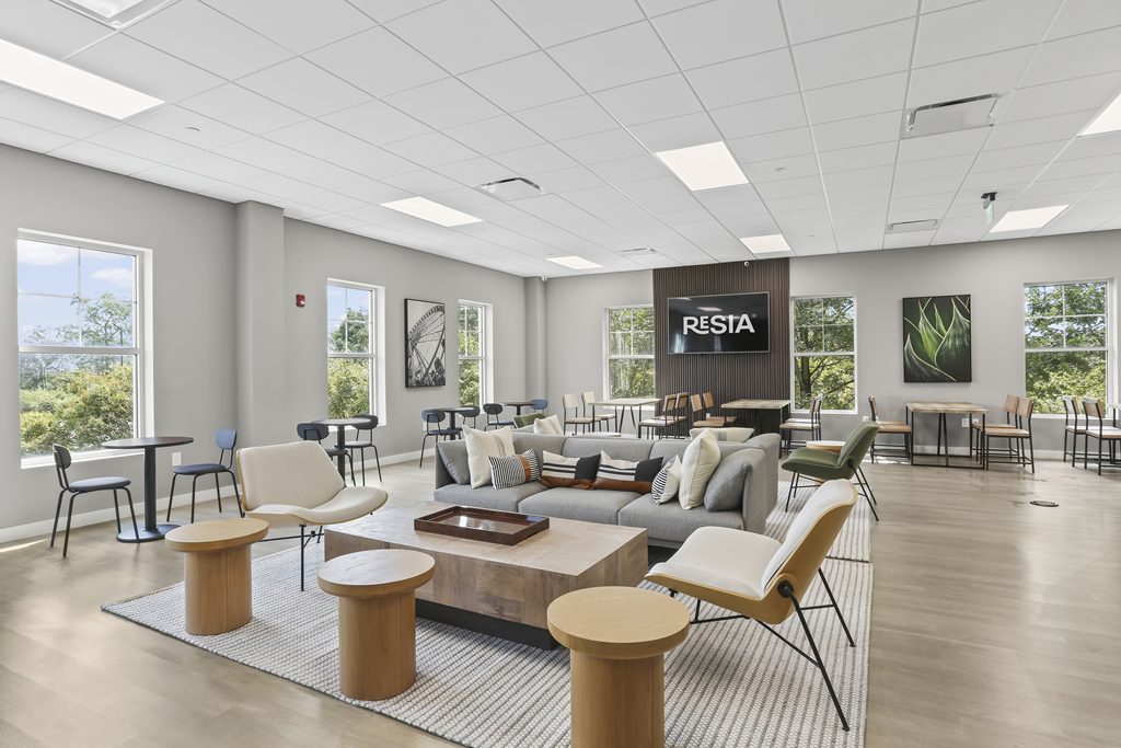 A spacious room with a sign that reads "RESTA" and various seating options.