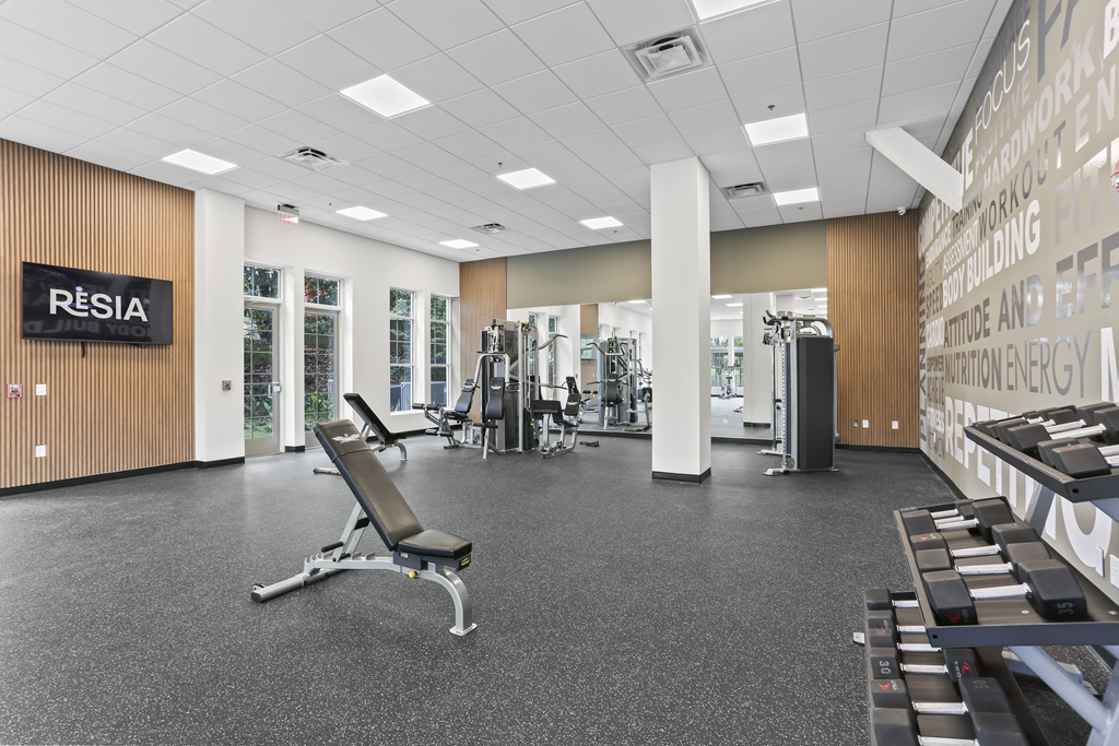 a large exercise room with treadmills and free weights