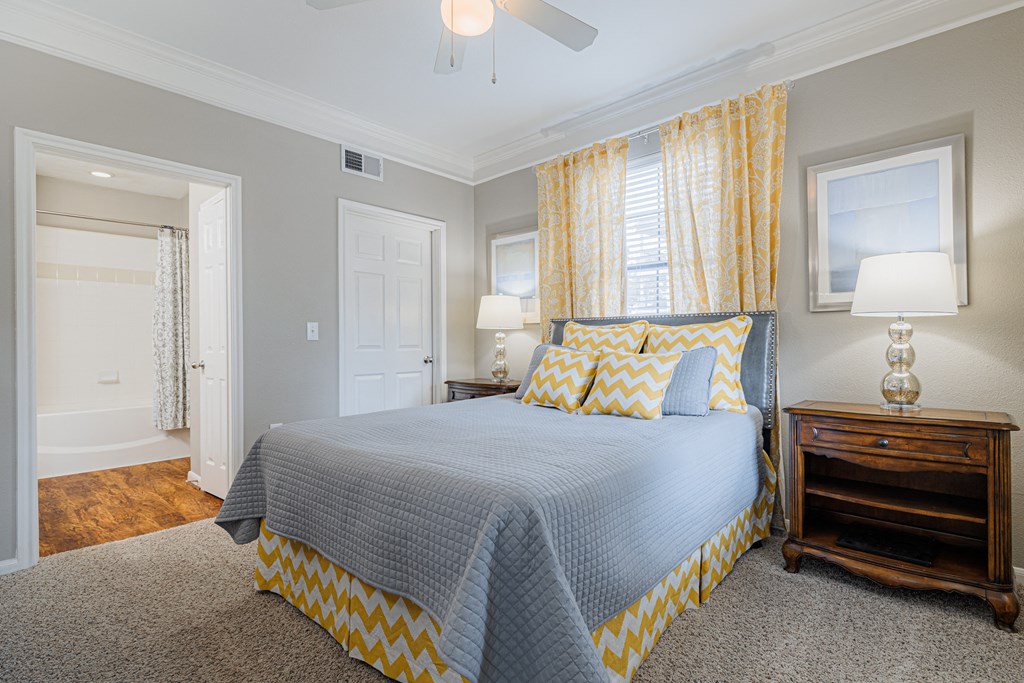 a bedroom with a large bed and yellow curtains