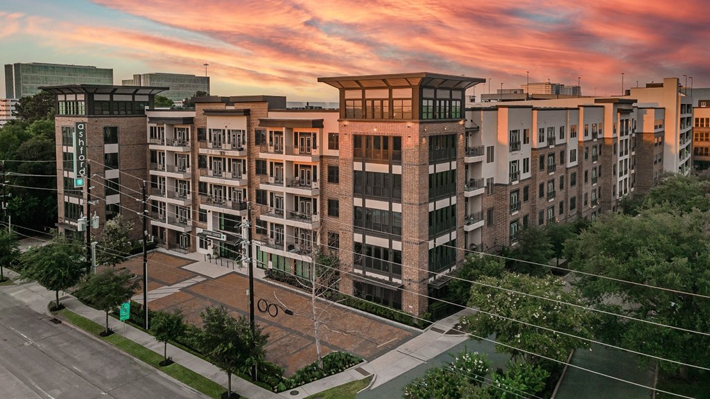 A large apartment complex with a parking lot in front.