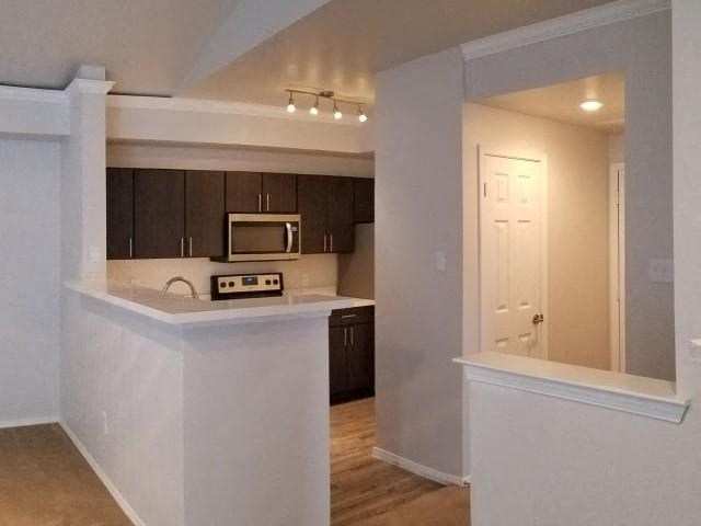 an empty kitchen with a stove and a microwave