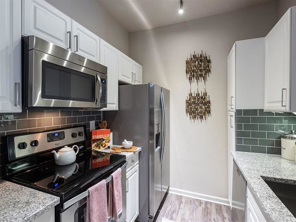 a kitchen with a stainless steel refrigerator and microwave