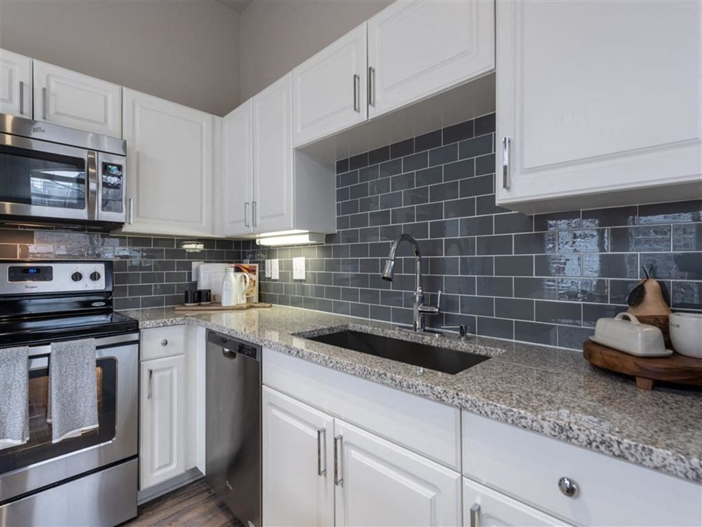 a kitchen with white cabinets and a sink