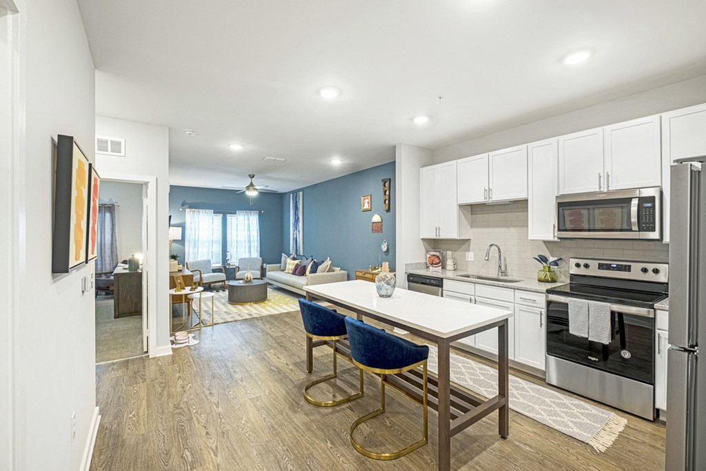 a kitchen and living room with white cabinets and blue walls