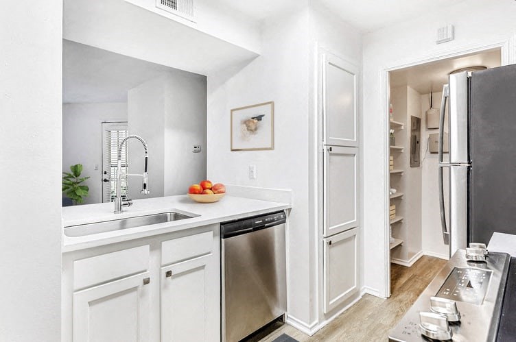 a kitchen with white cabinets and stainless steel appliances
