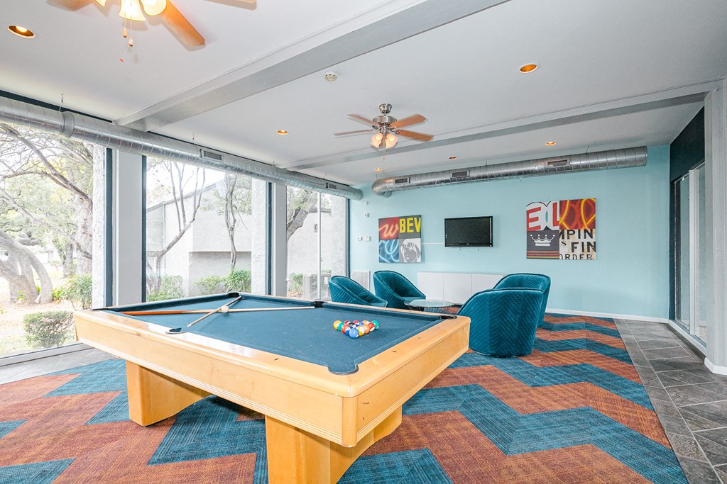 a game room with a pool table and chairs