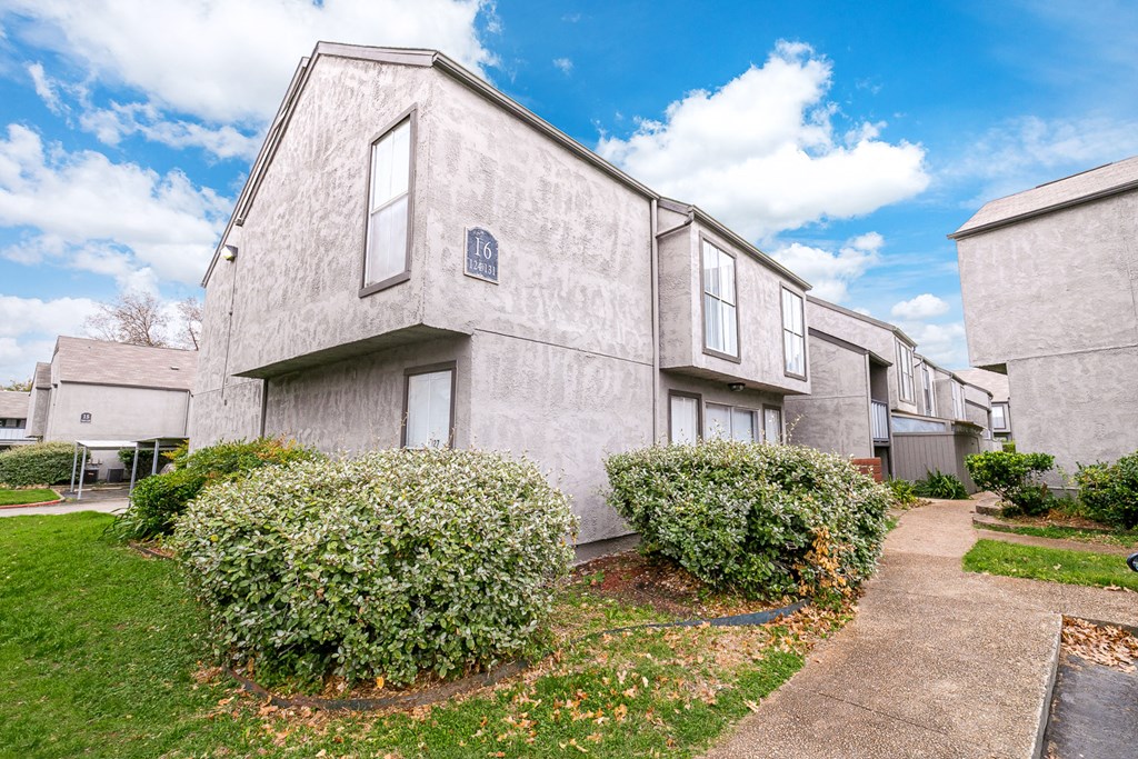 a view of the exterior of a building at the whispering winds apartments in pearland, tx