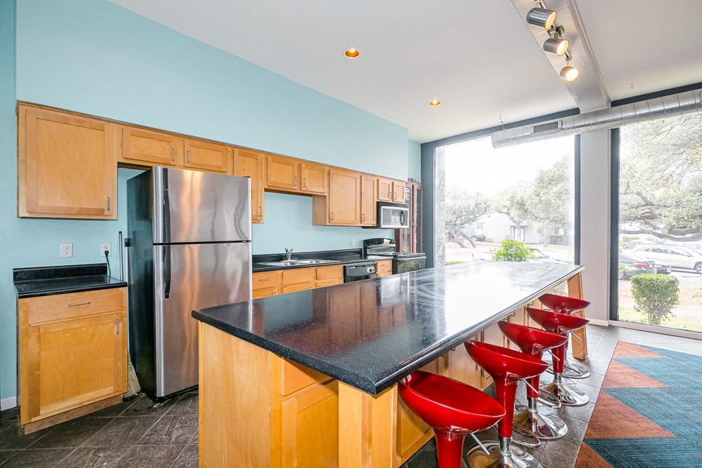 a kitchen with an island and red bar stools