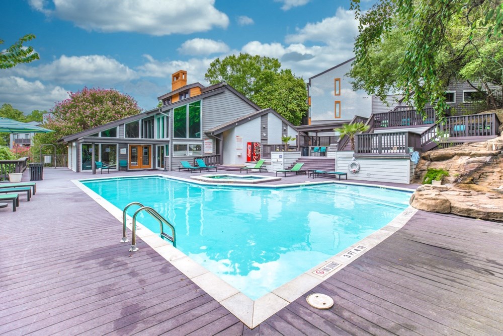 a large swimming pool with a house in the background