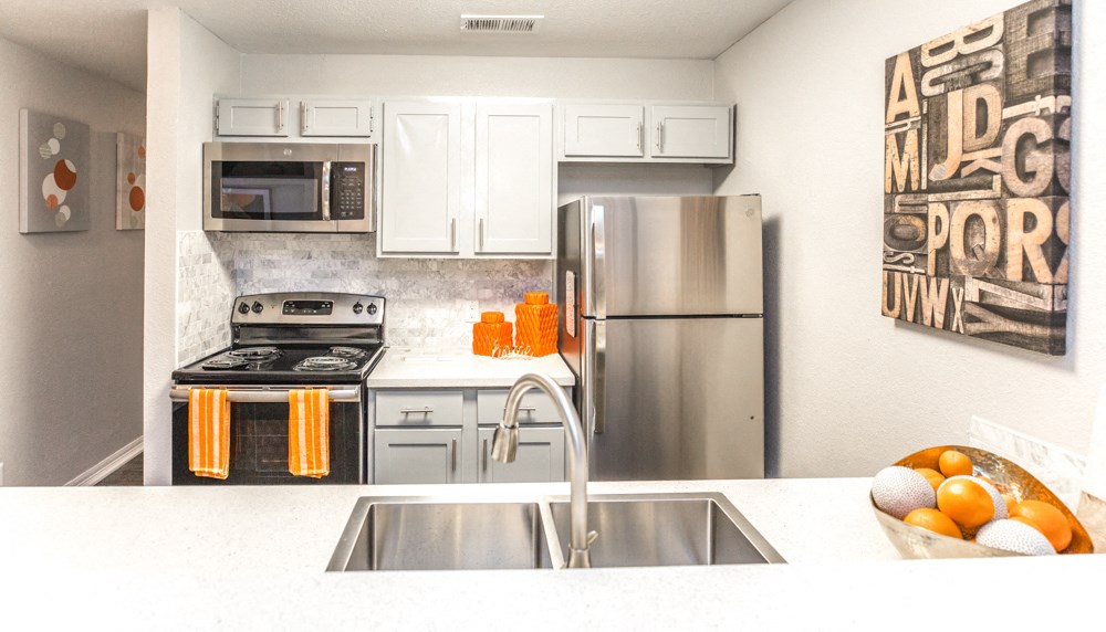 a kitchen with white cabinets and stainless steel appliances