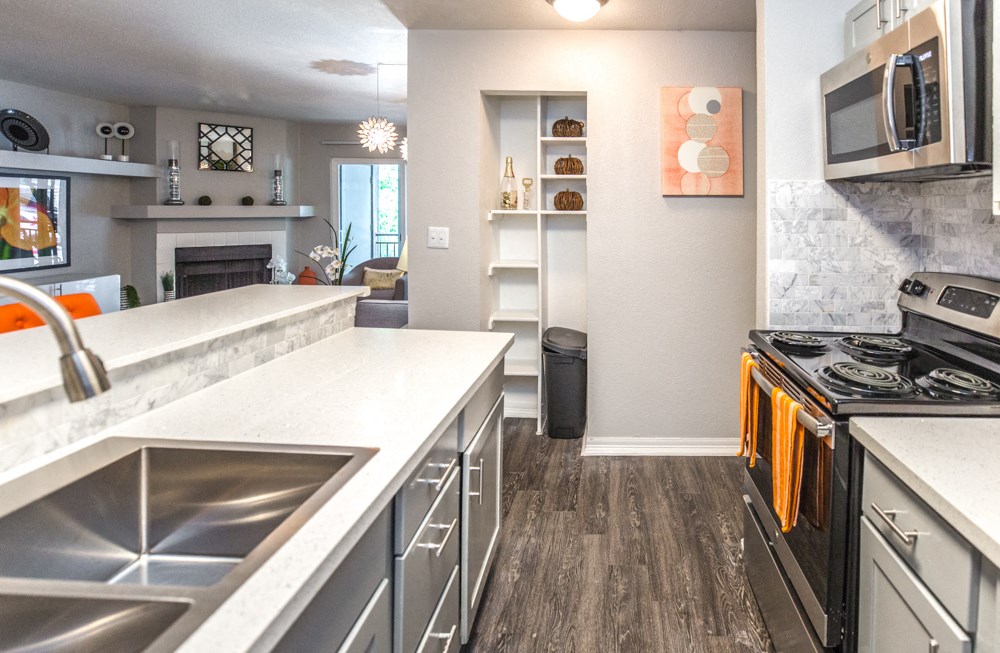 a kitchen with white countertops and stainless steel appliances