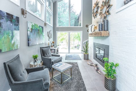 a living room with two chairs and a fireplace