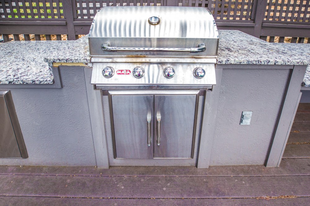 a stainless steel barbecue with granite countertops
