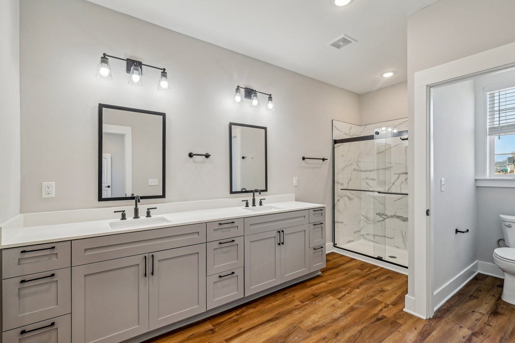 A bathroom with two sinks and a walk-in shower.