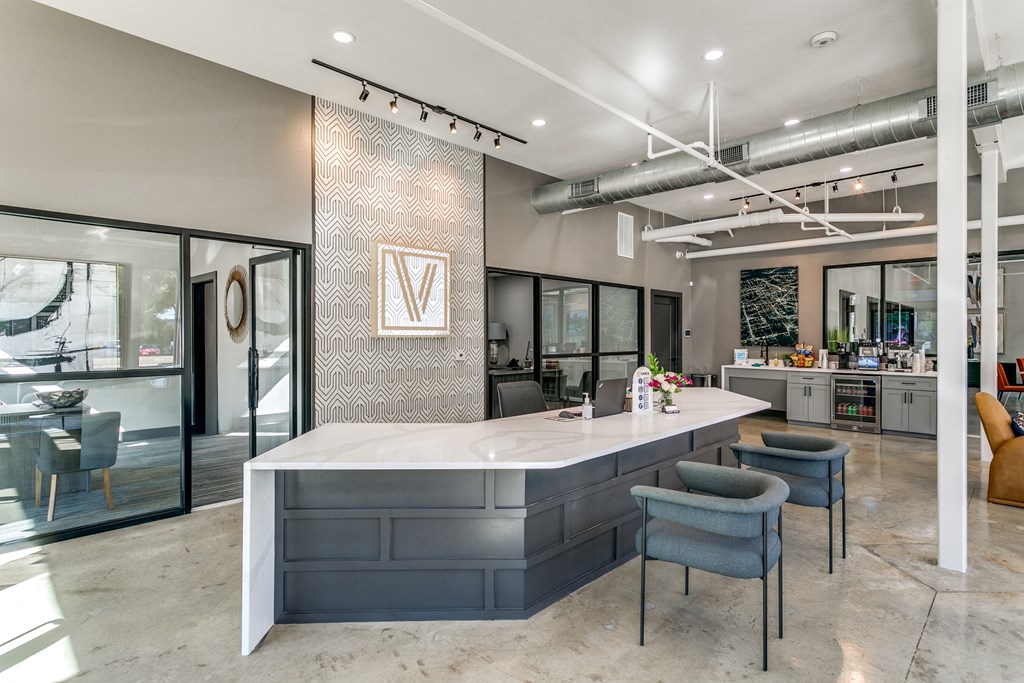 a kitchen with a large counter and chairs in a lobby