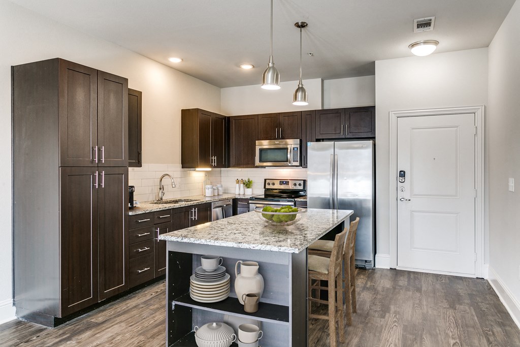 a kitchen with stainless steel appliances and a marble counter top