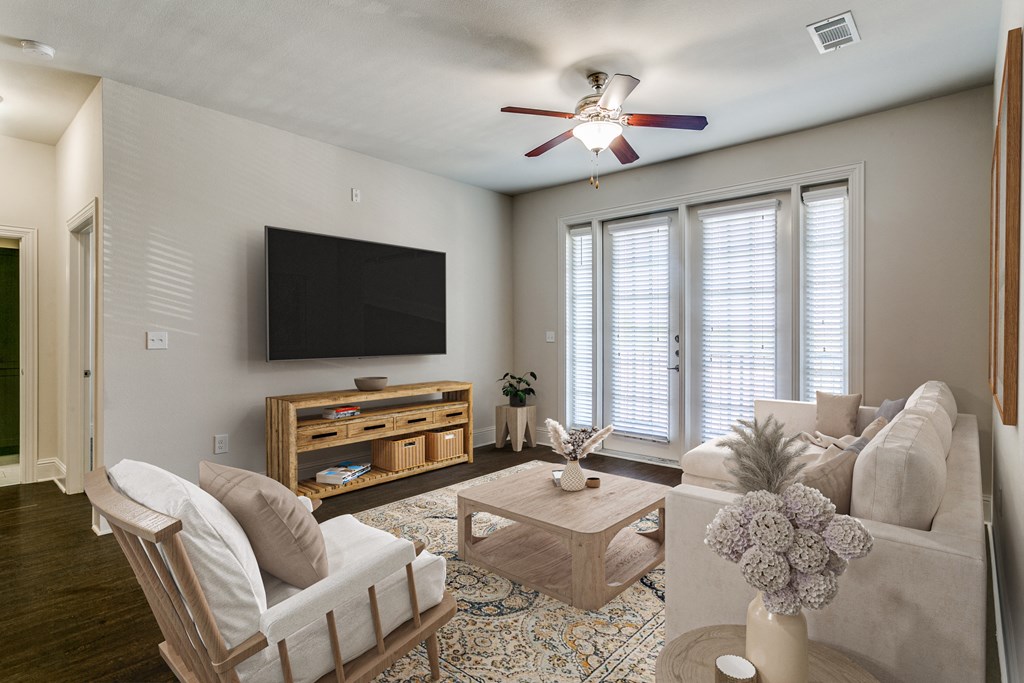 a living room with a ceiling fan and a tv