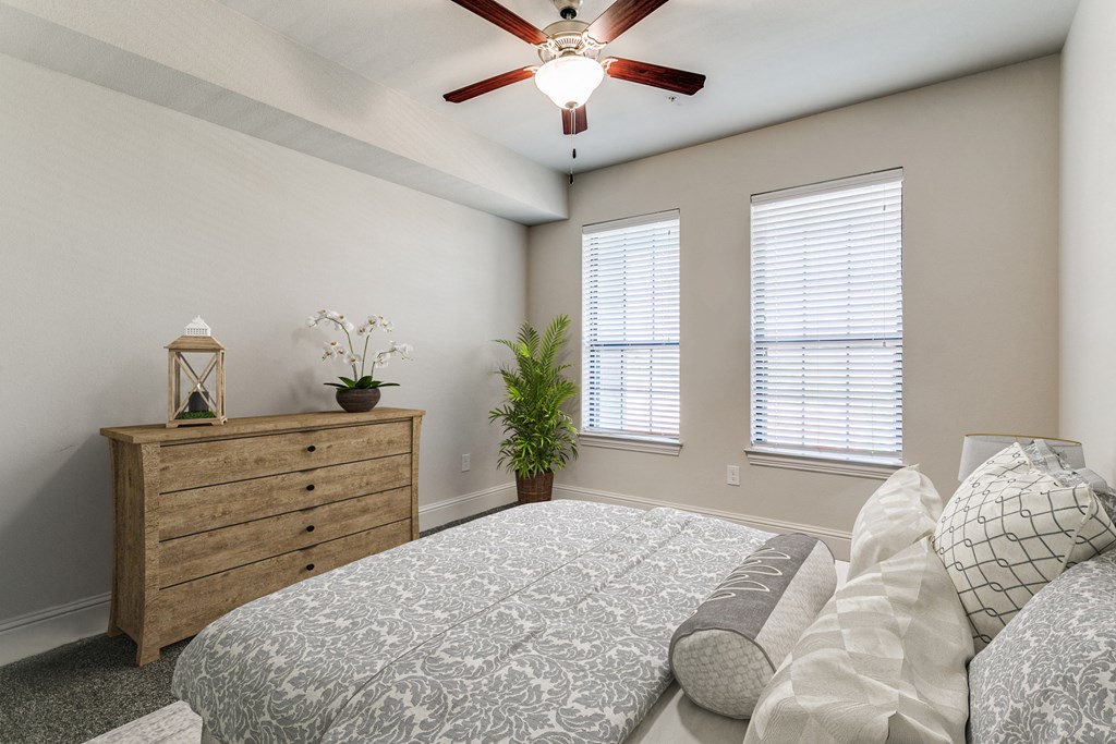 an empty bedroom with a bed and a ceiling fan