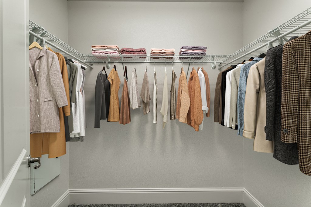 a closet with a rack of clothes hanging in it