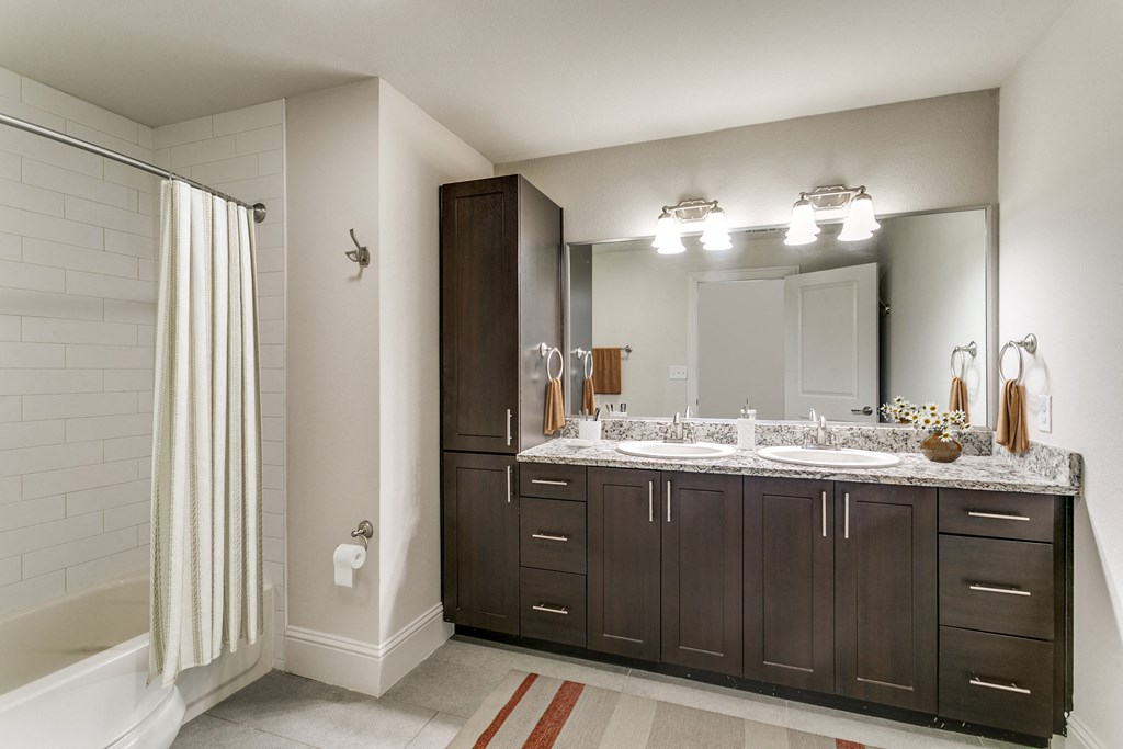 a bathroom with two sinks and a shower and a mirror