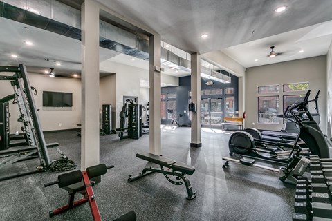 a gym with weights and other exercise equipment and a tv