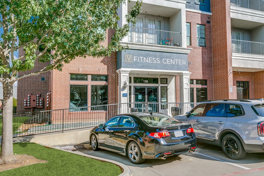 two cars parked in front of a fitness center