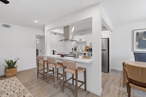 A kitchen with a bar area and a refrigerator.