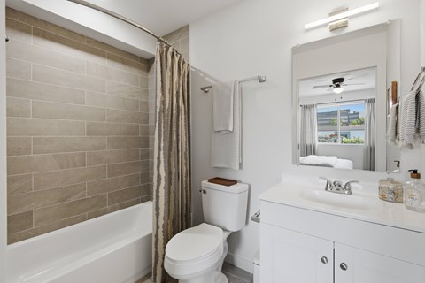 A white bathroom with a toilet, sink, and bathtub.
