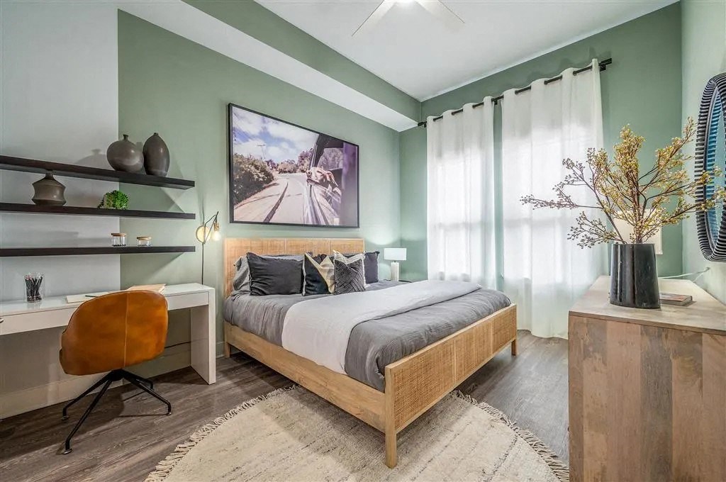 a bedroom with green walls and a bed and a desk