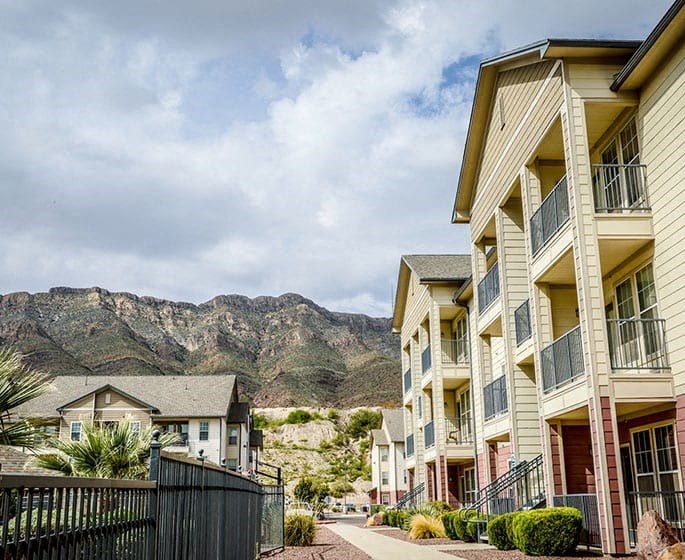 a row of apartments with mountains in the background