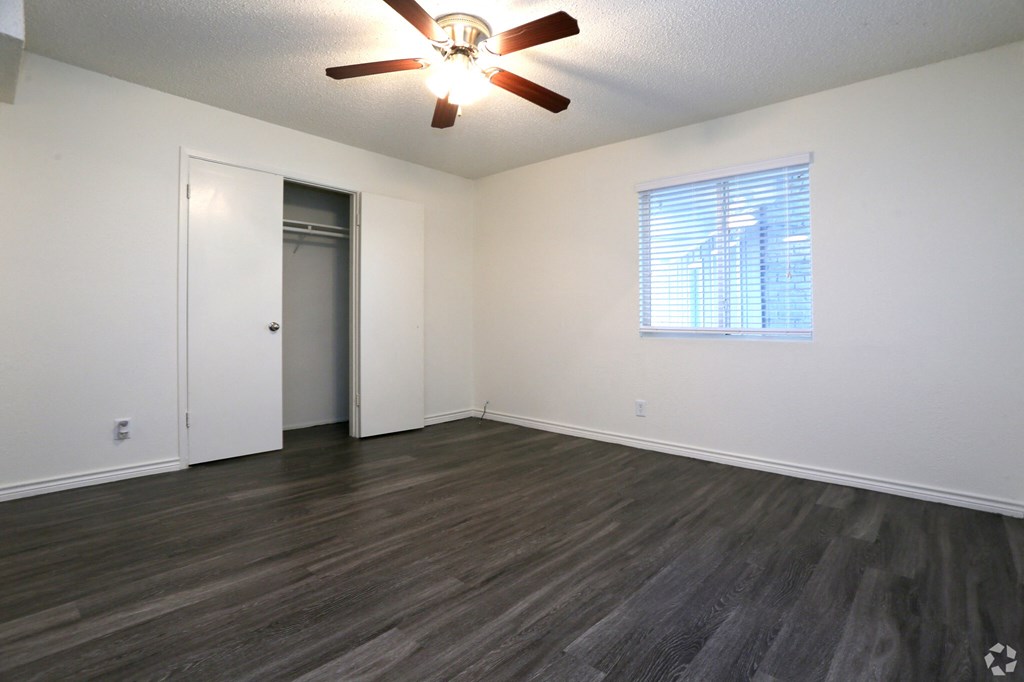 a bedroom with hardwood floors and a ceiling fan