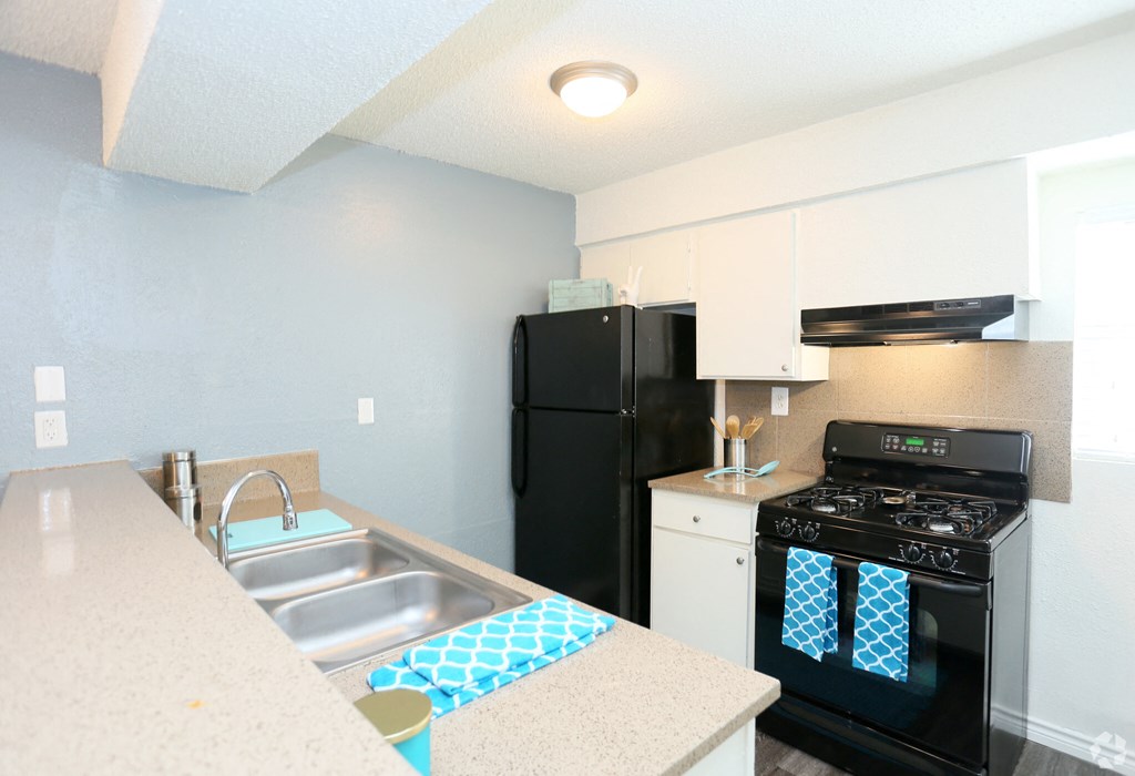 a kitchen with white cabinets and black appliances