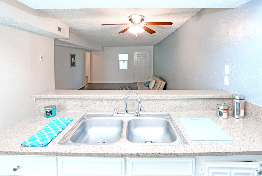 a kitchen with a sink and a ceiling fan