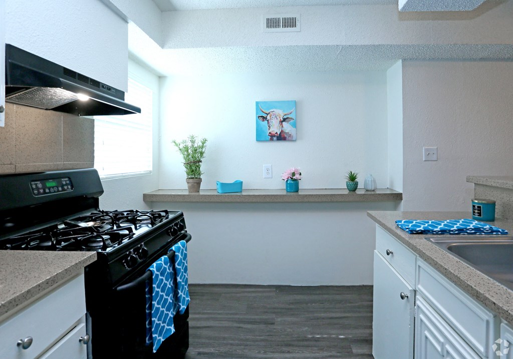 a kitchen with white cabinets and a black stove top oven
