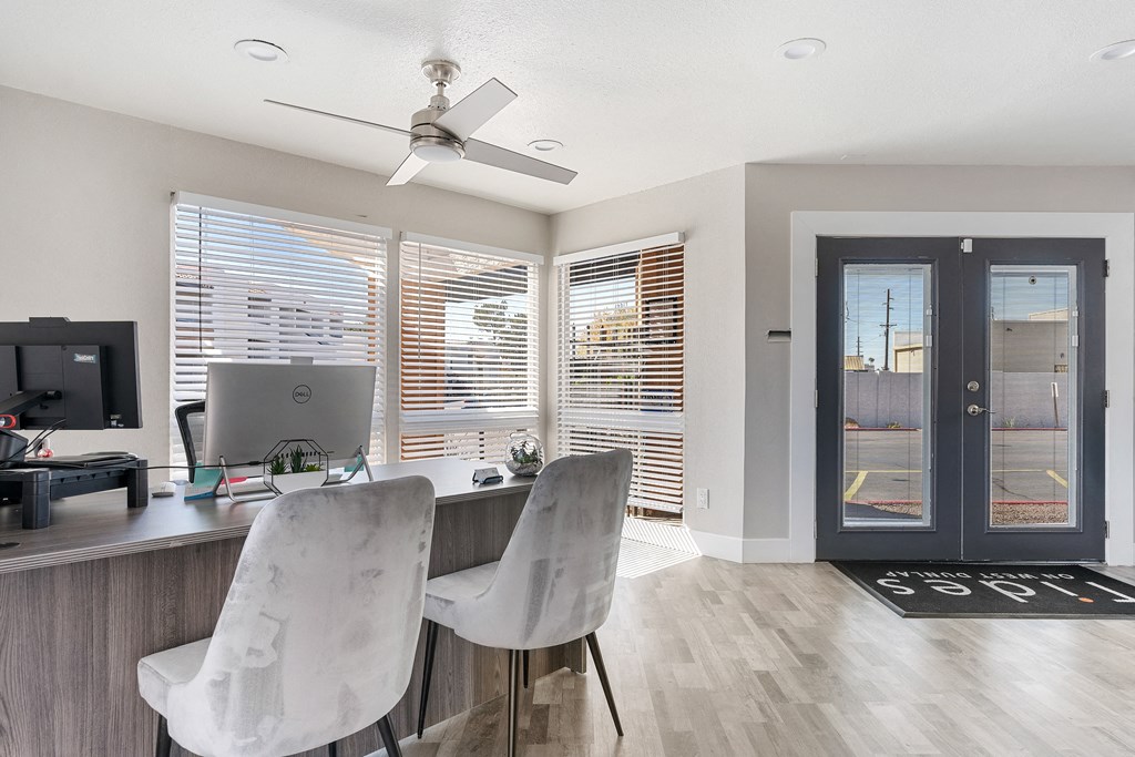 a home office with a desk and chairs and a computer