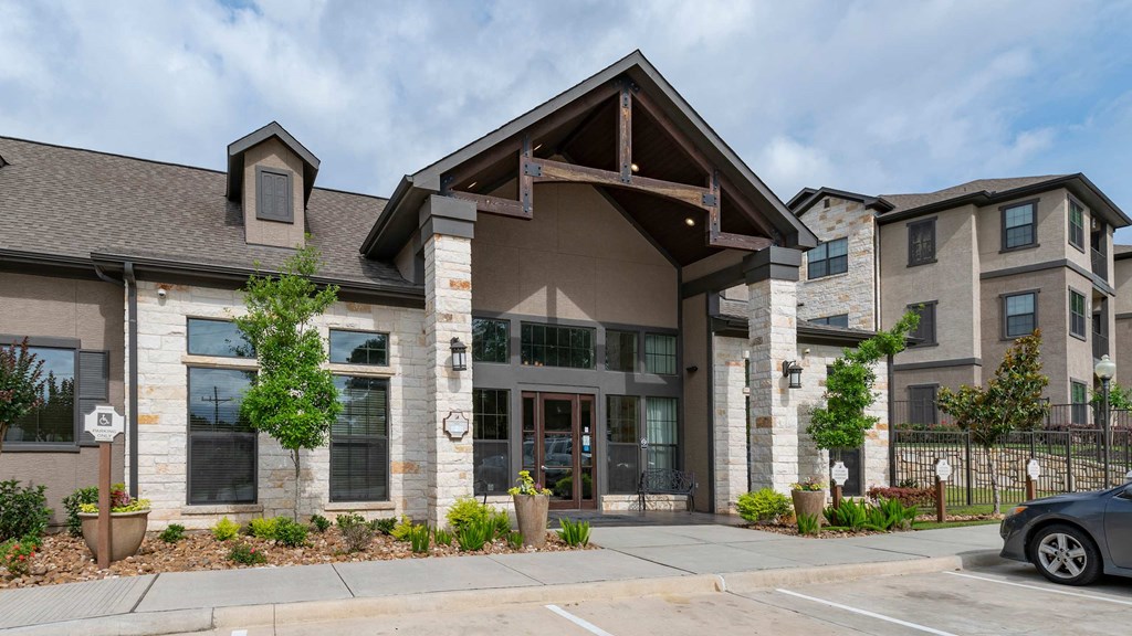A modern building with a stone facade and a large glass entrance.