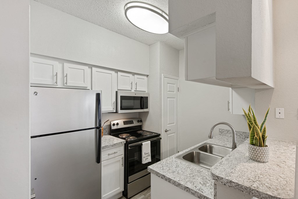 an apartment kitchen with stainless steel appliances and granite counter tops