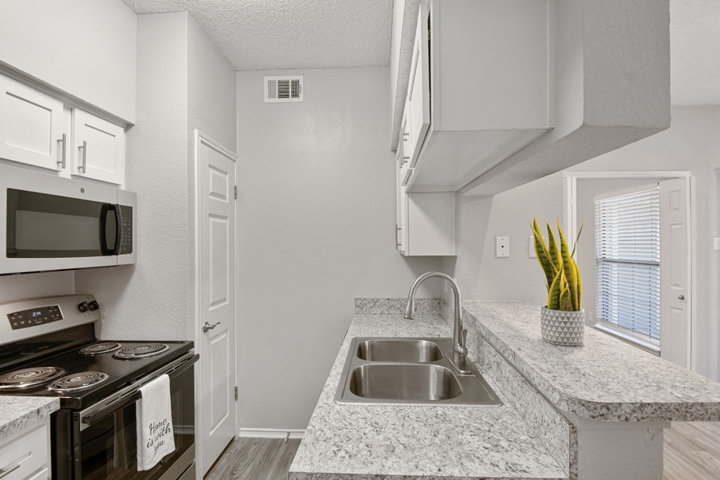 a renovated kitchen with granite counter tops and a sink