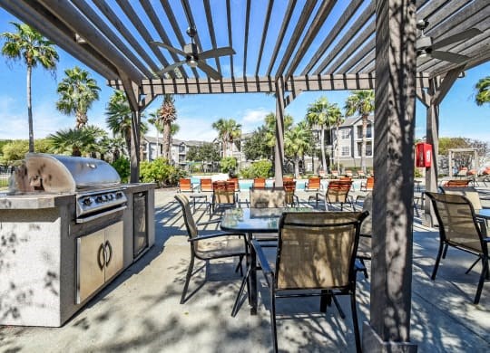 a patio with a barbecue grill and tables and chairs