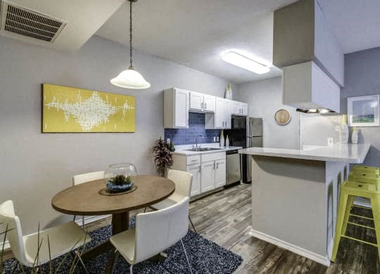 a kitchen and dining room with a table and chairs