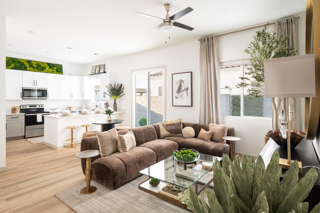 A modern living room with a brown couch and a glass coffee table.