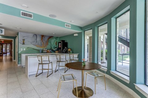 A kitchen with a table and chairs.