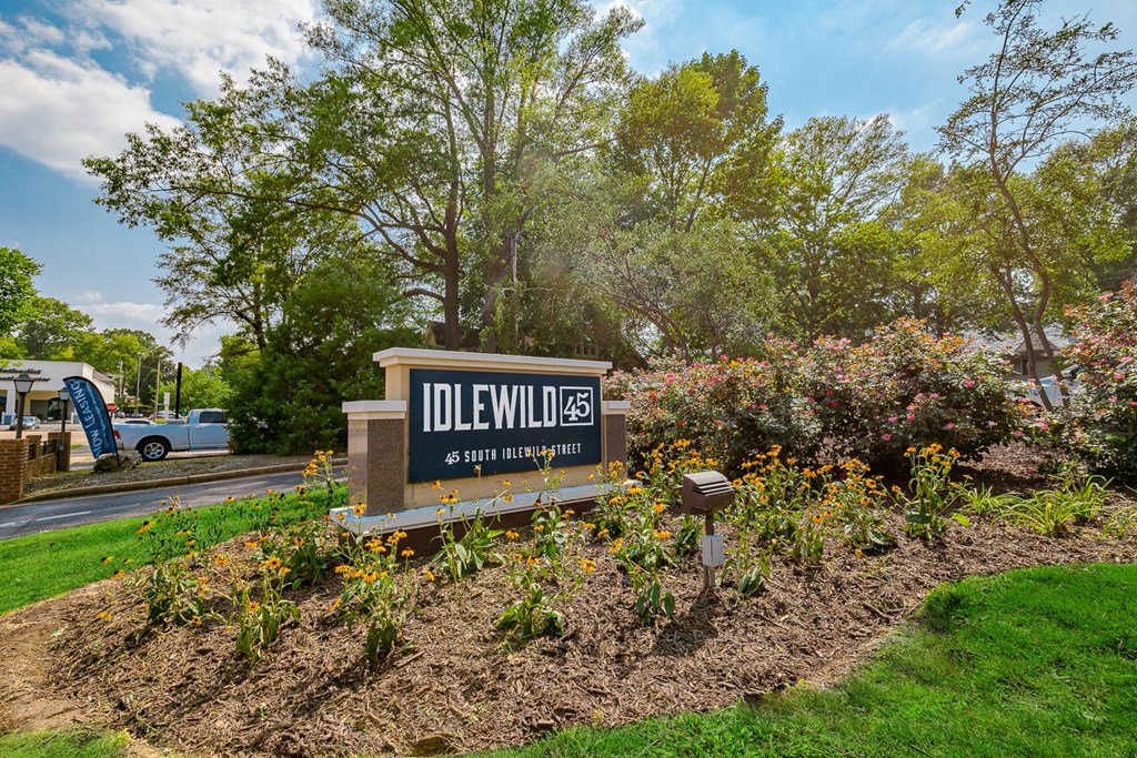 a sign in front of a building with trees in the background